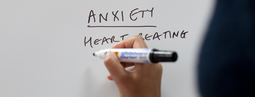 Person writing anxiety on whiteboard