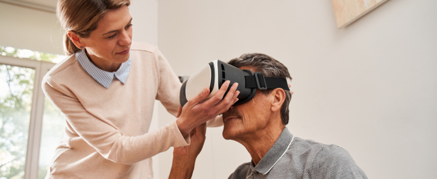 woman fitting a VR headset on an older man