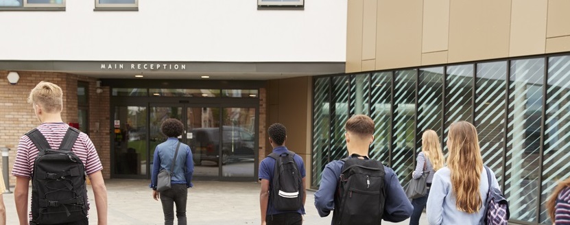 young people walking into the entrance of a high school