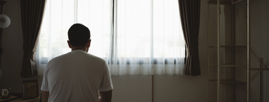 Silhouette depressed man sadly sitting on the bed in the bedroom.